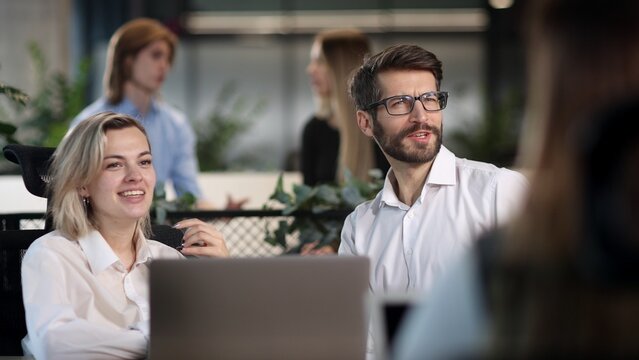 A man and a woman are sitting at a table with a laptop in front of them