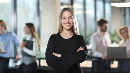 A woman in a black sweater is smiling and posing for a photo