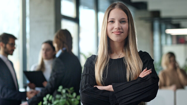 A woman in a black shirt stands in front of a group of people