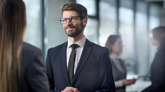 A man in a suit is smiling at a woman