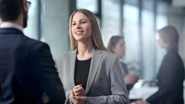 A woman in a business suit is talking to a man in a suit