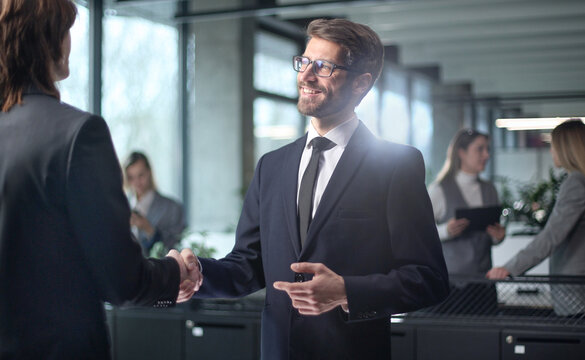 A man in a suit shakes hands with another man