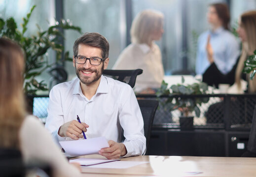 A man is sitting at a desk with a woman in front of him