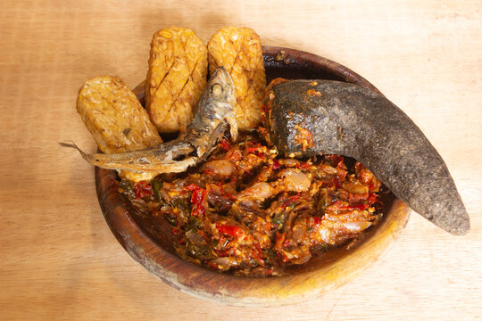 Close-up of sambal ulek served with fried tempeh and salted fish, highlighting bold flavors, rich texture, and authentic Indonesian traditional food pairing.