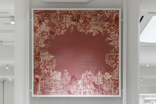 Framed red Toile de Jouy artwork with cityscape patterns and the Eiffel Tower on a white wall.
