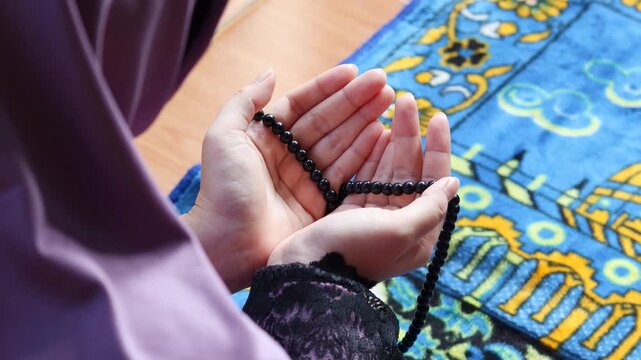 Close up of Muslim woman hands raised in prayer. Female making dua during worship at home. Spiritual devotion, faith and peaceful religious moment concept.
