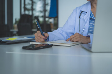 Close Up Female Doctor Writing Medical Notes at Desk