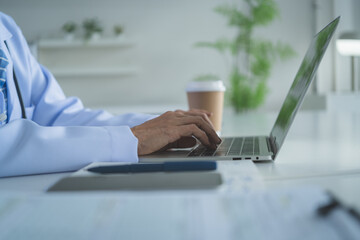 Close Up Doctor Typing on Laptop in Modern Medical Office