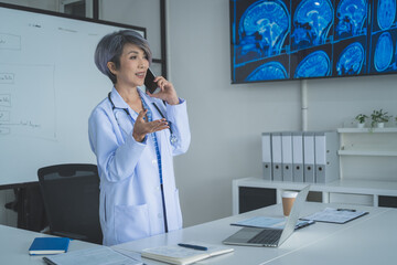 Senior Female Doctor Explaining Medical Advice During Phone Call