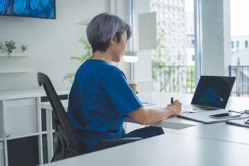 Rear View Female Doctor Working on Laptop in Bright Medical Office