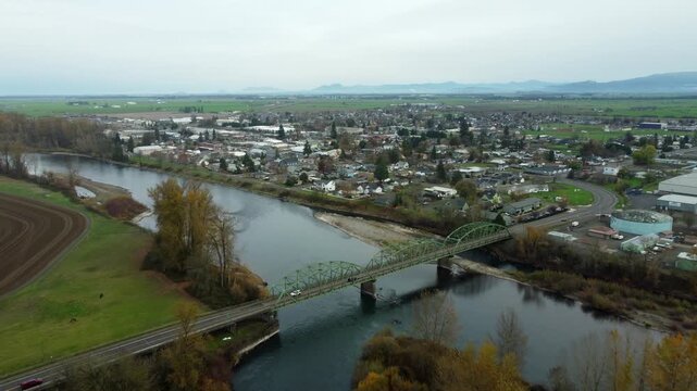 US, OR, Harrisburg, , 2025-11-23 - Drone view of the Wilamette River Iron Bridge on 3rd street with the city and the Wilamette Valley beyond, in fall