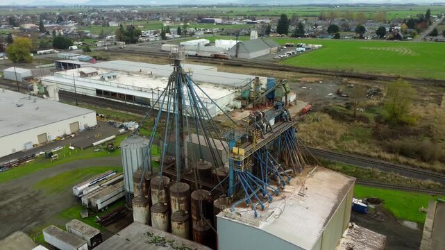 US, OR, Harrisburg, , 2025-11-23 - Drone view of a chemical processing plant with old dirty pipes leading to a tower at CHS Nutrition, in fall