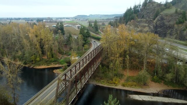 US, OR, Eugene, , 2025-11-23 - Drone view of the Coburg Bridge, old railroad bridge that is now a walking path, and I-5 beyond over the McKenzie River in fall