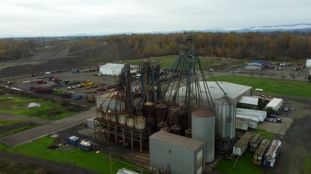 US, OR, Harrisburg, , 2025-11-23 - Drone view of a chemical processing plant with old dirty pipes leading to a tower at CHS Nutrition, in fall