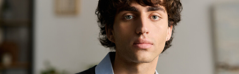 Fototapeta premium Curly-haired young man exudes confidence in his stylish modern apartment space