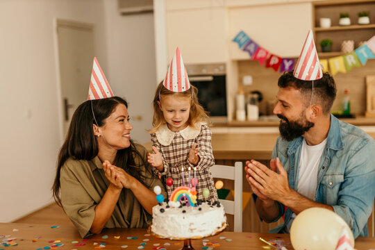 Child celebrating with cake and party hats