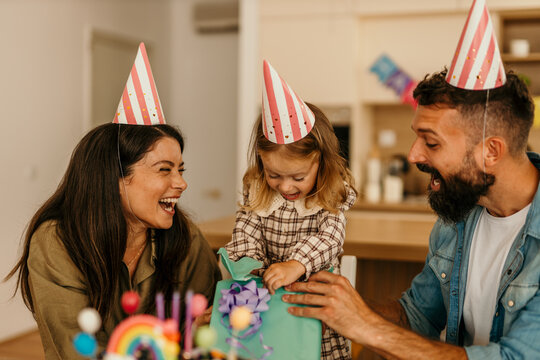 Family opening present during a cheerful home gathering