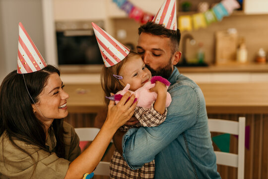 Family wearing party hats celebrating daughter's special day