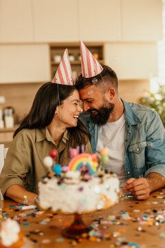 Happy couple celebrating birthday with cake and confetti