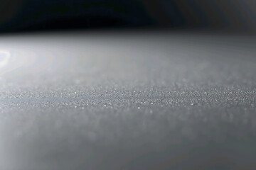 Settled micro dust layer on flat surface with fine particles, soft lighting, minimal contrast, neutral gray abstract background texture.