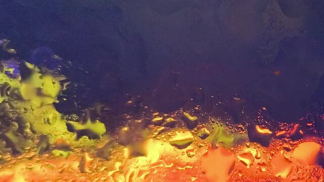 Underwater scene with vibrant yellow and orange fish swimming near a coral reef in a dark blue ocean with warm sunlight filtering through.