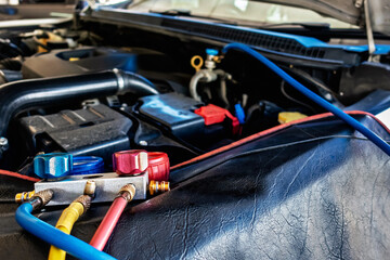 A/C Manifold Gauges Set. Check pressure and leak for use air conditioning systems. Recharging car air conditioner with refrigerant using grade gear with separate gauges to monitor pressure in system.