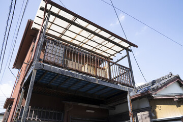 錆びたバルコニーのある二階建て一軒家