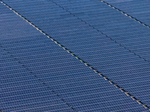 Aerial view of a vast expanse of solar panels reflecting the sky, creating a blue monochromatic landscape, Gaibandha, Rangpur Division, Bangladesh.