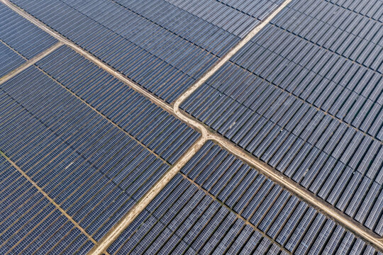Aerial view of geometric precision as solar panels stretch across the landscape, capturing sunlight with stark efficiency, Gaibandha, Rangpur Division, Bangladesh.