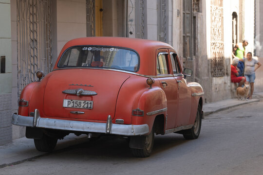 Old classic retro American Dodge car from 50's parked on an old narrow street in Havana, Cuba, surrounded by colonial buildings. Selective focus. 