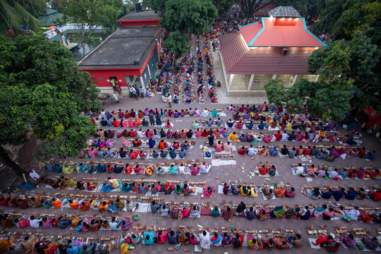 Aerial view of rows of people seated on mats in a courtyard, possibly during a community meal or gathering, Narayanganj, Dhaka Division, Bangladesh.