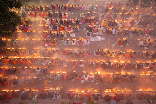 Aerial view of people gathered in concentric circles holding lights, creating a mesmerizing display of unity and warmth in the twilight, Narayanganj, Bangladesh.