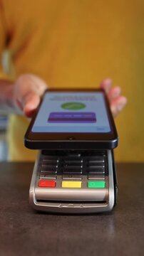 Customer using smartphone for contactless payment on a pos terminal for a secure and fast transaction