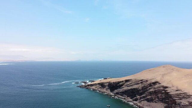 Drone aerial view, blue sea and clear sky blue mountain and boat in Paracas National Park, Peru 4k