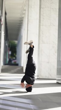 Street dancer performs a powerful headstand freeze and transitions to a grounded finish in a sunlit marble corridor, showcasing balance, strength, and dynamic urban choreography.