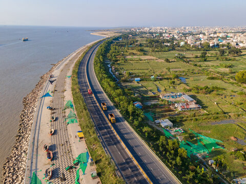 Chattogram, Bangladesh - 30 November 2023: Aerial view of the Marine Drive road contrasting with the Bay of Bengal's blue waters and the city's green landscape.