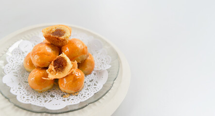 Pineapple tarts, golden glossy stacked on white, traditional festive dessert Concept.