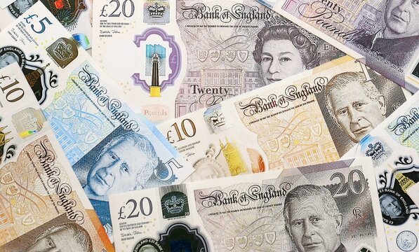 British pound money bills pile on table. United Kingdom banknotes of GBP currency close up.