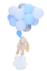 Cute beige plush bunny hanging on blue and white balloons for baby boy shower © Grigor