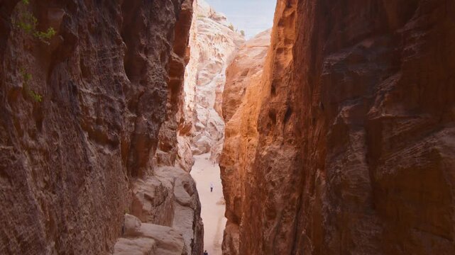 Little Petra Jordan canyon static timelapse with tourists walking in motion through sandstone corridor, ancient Nabataean site, desert travel mood, heritage tourism concept
