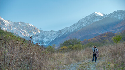 Obraz premium Female Hiker with Backpack Looking at Snowy Mountain Glacier with Copy Space