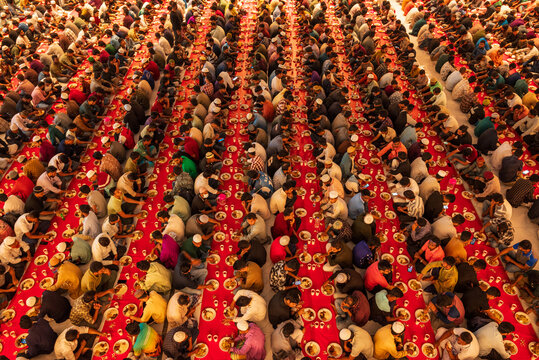 Dhaka, Bangladesh - 25 February 2026: Aerial view of rows of people gathered for Iftar at the mosque, creating a sea of red and brown tones.