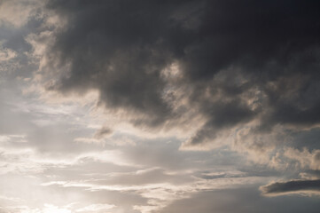 Fototapeta premium Dramatic sunset sky with dark storm clouds and soft light, moody atmosphere before rainfall