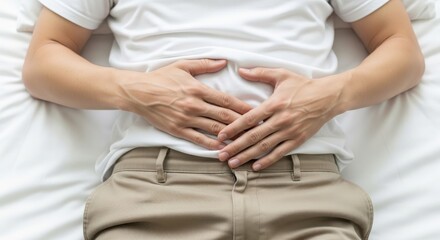 Person experiencing discomfort or bloating while sitting on a bed