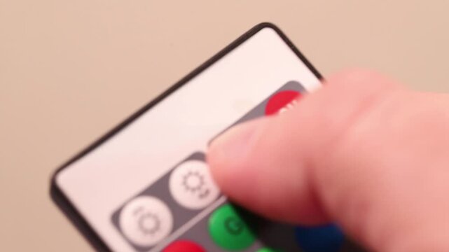 Macro close-up of a finger pressing the white OFF button on a remote control.
