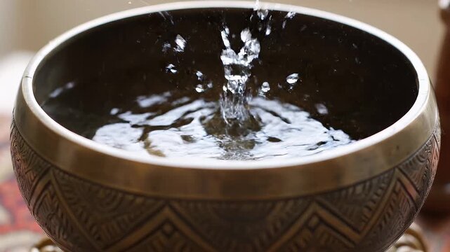 Water Droplet Falling into a Tibetan Singing Bowl Creating Ripples.