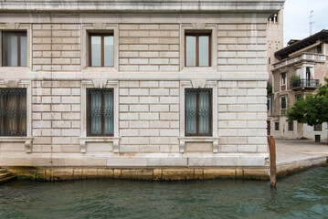 White stone Venetian palace facade with iron window grilles