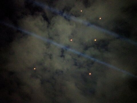 Mysterious Light Beams and Glowing Orbs in the Dark Night Sky with Clouds