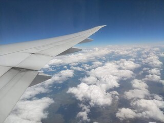 Obraz premium View from Airplane Window of Wing Over Vast White Cloud Formations