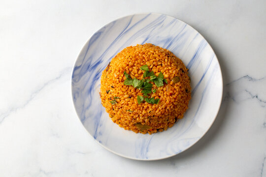 Traditional turkish bulgur pilaf with tomato sause in plate (Turkish name; meyhane pilavi)